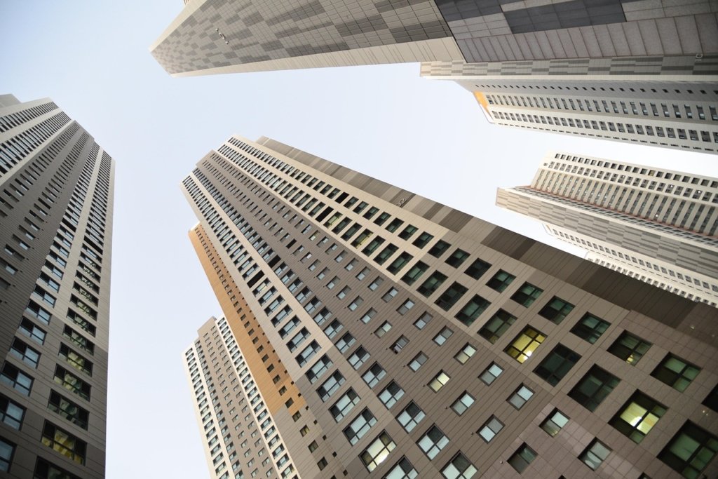 Modern high-rise buildings viewed from below, symbolizing urban real estate development.Vengurla