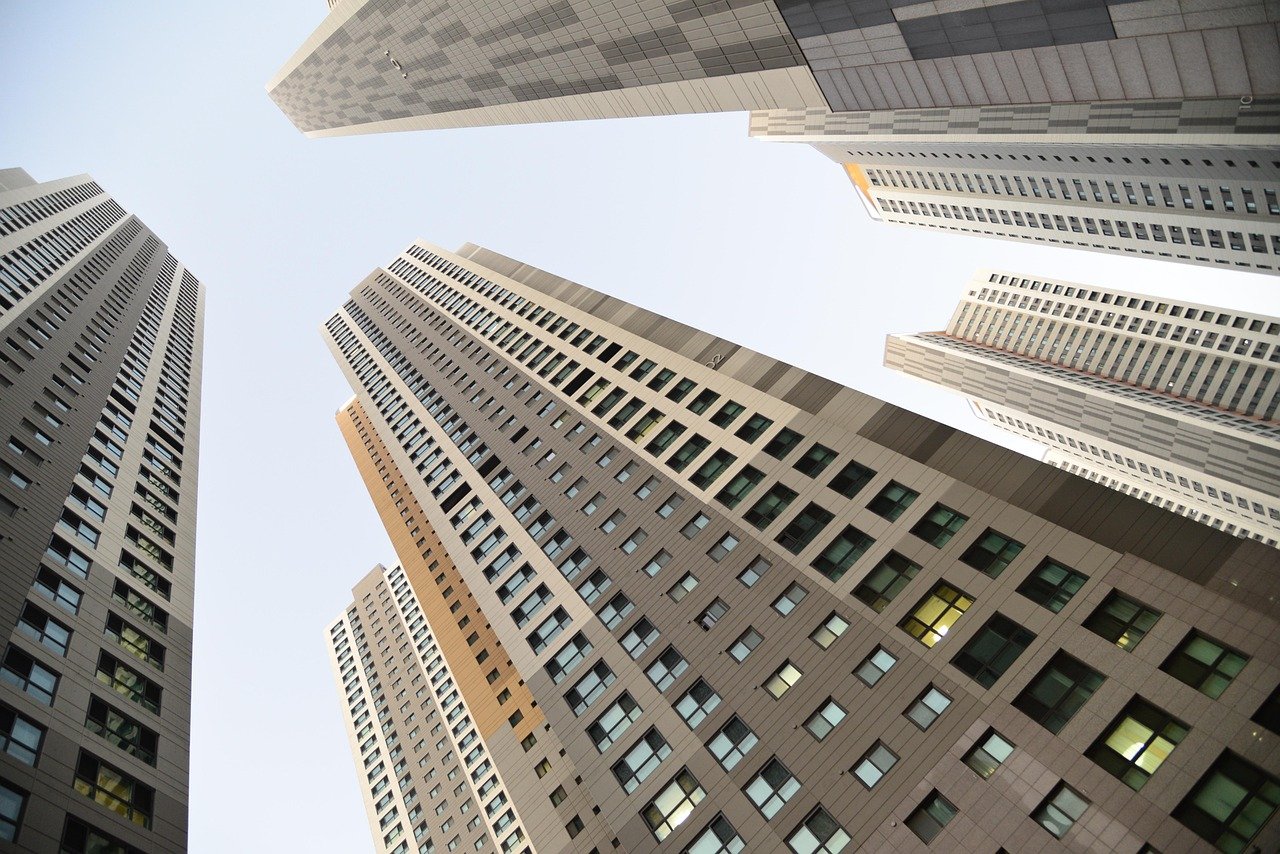 Modern high-rise buildings viewed from below, symbolizing urban real estate development.Vengurla