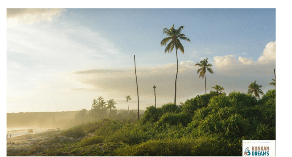 “Scenic view of Vengurla beach with coconut trees, lush green vegetation, and a misty coastline under a cloudy monsoon sky.”